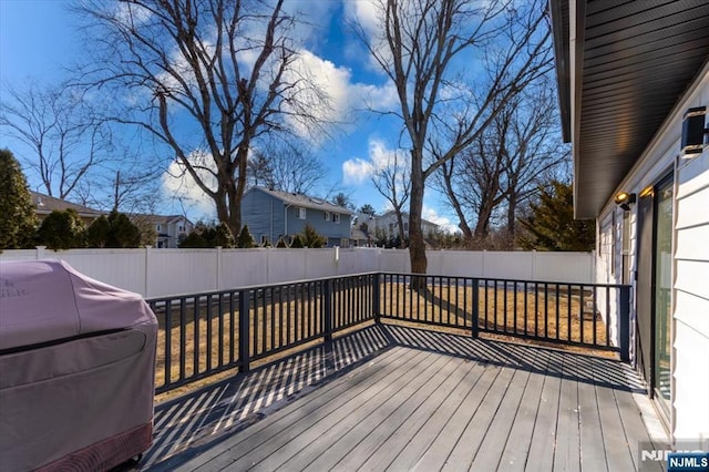 wooden terrace with a fenced backyard