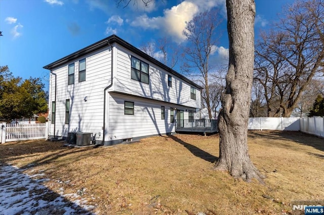 back of property with a deck, a yard, central AC, and a fenced backyard