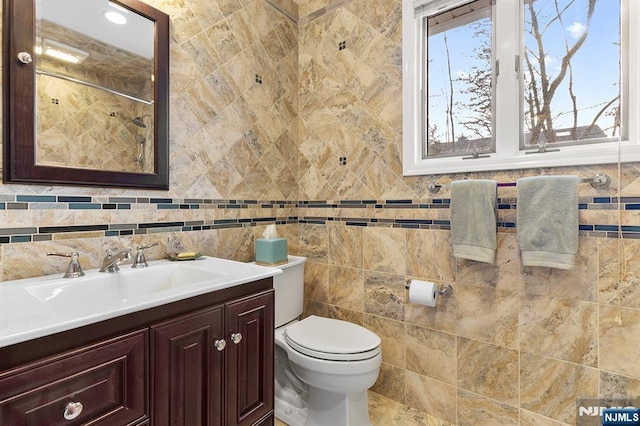 full bathroom featuring toilet, tile walls, and vanity