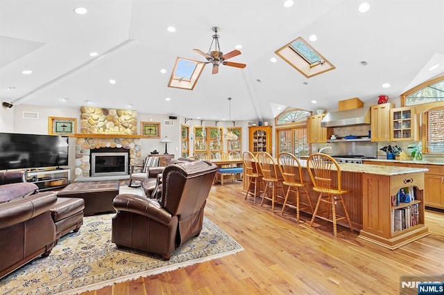 living area featuring a skylight, plenty of natural light, and light wood-style flooring