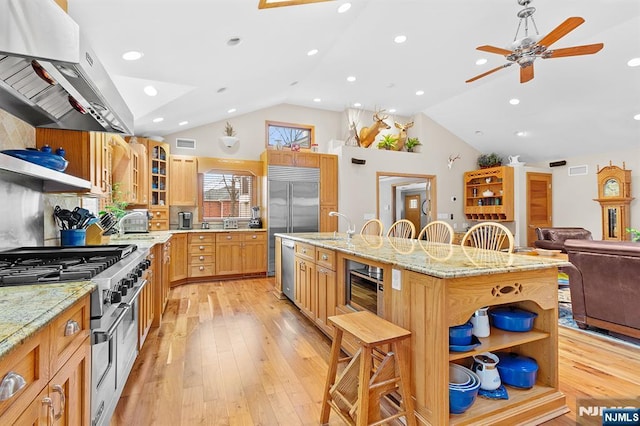 kitchen with premium appliances, a breakfast bar, open shelves, glass insert cabinets, and a kitchen island