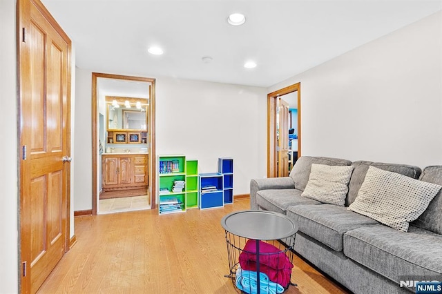 living area with baseboards, wood finished floors, and recessed lighting