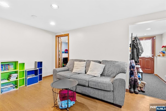 living area featuring light wood-style flooring, baseboards, and recessed lighting