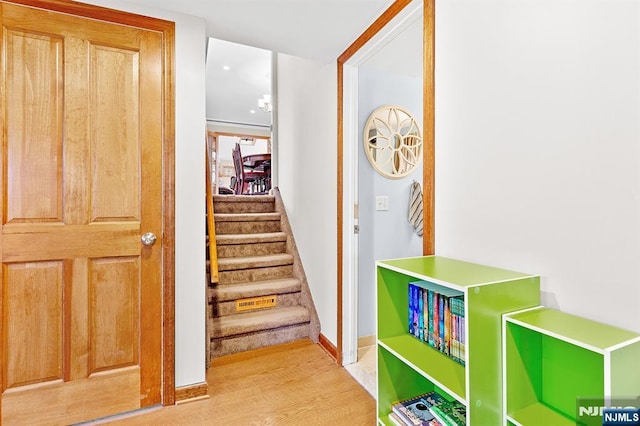 staircase featuring baseboards and wood finished floors