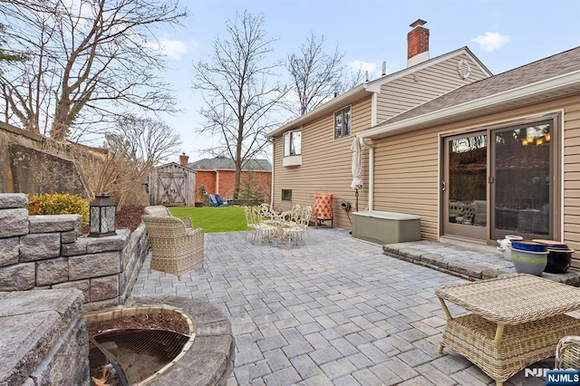 view of patio / terrace featuring outdoor dining space, an outbuilding, and a shed