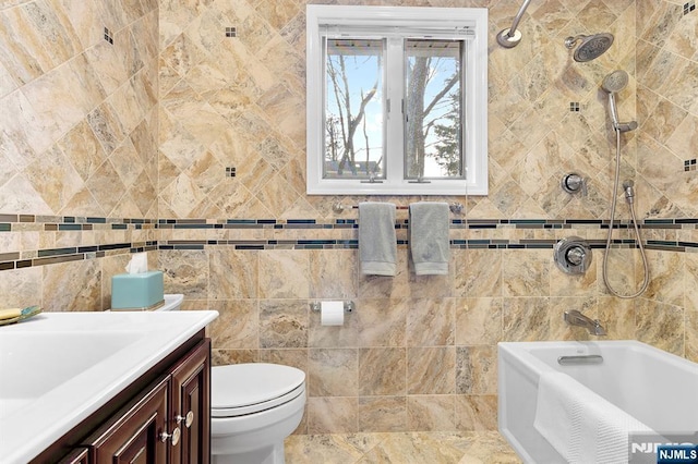 bathroom featuring toilet, bathtub / shower combination, tile walls, and vanity