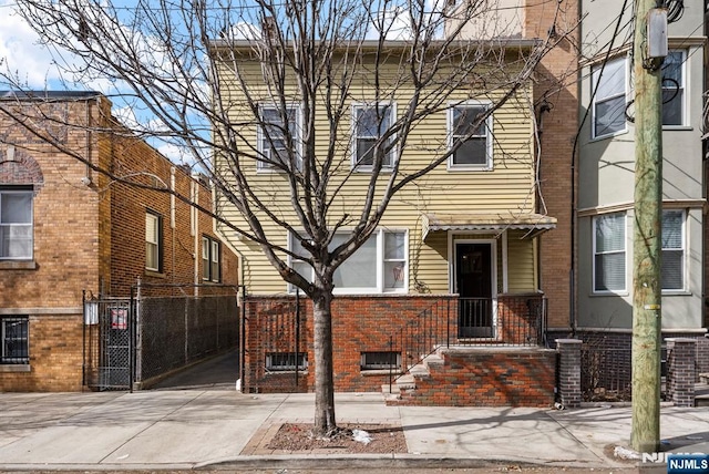 multi unit property featuring central AC, brick siding, and fence