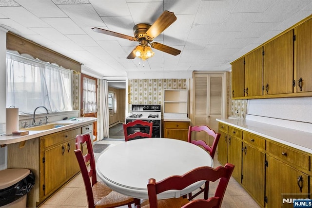 kitchen with a ceiling fan, light countertops, a sink, and light tile patterned floors