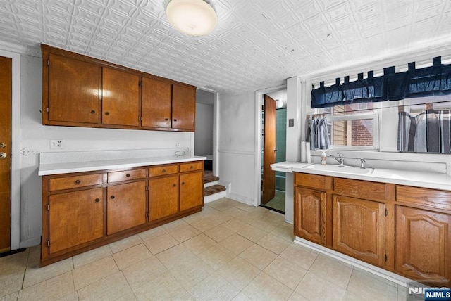 kitchen featuring an ornate ceiling, brown cabinets, and a sink