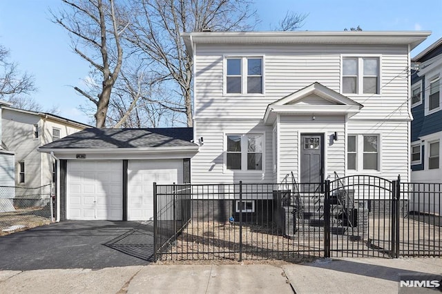 view of front of house featuring a fenced front yard, a detached garage, and a gate