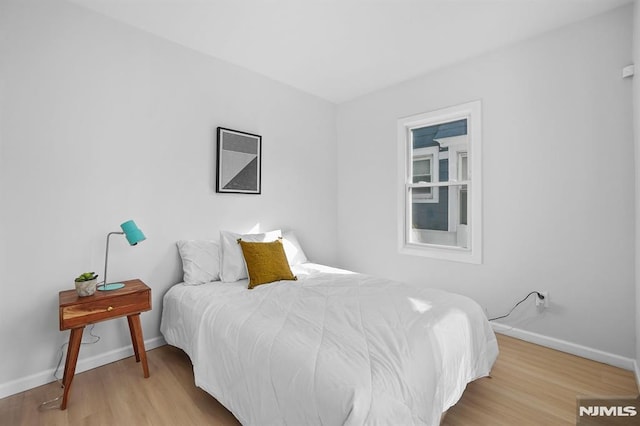 bedroom with baseboards and wood finished floors