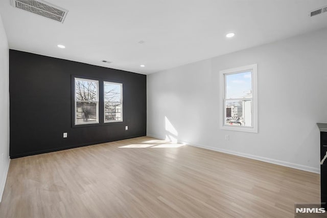 spare room with baseboards, recessed lighting, visible vents, and light wood-style floors