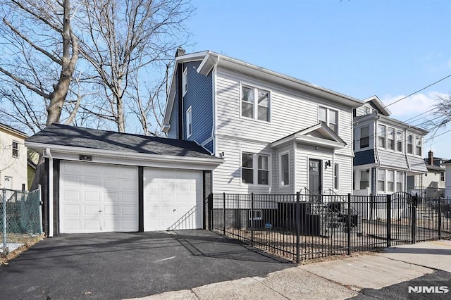 view of front of property featuring an attached garage, a chimney, fence, and aphalt driveway