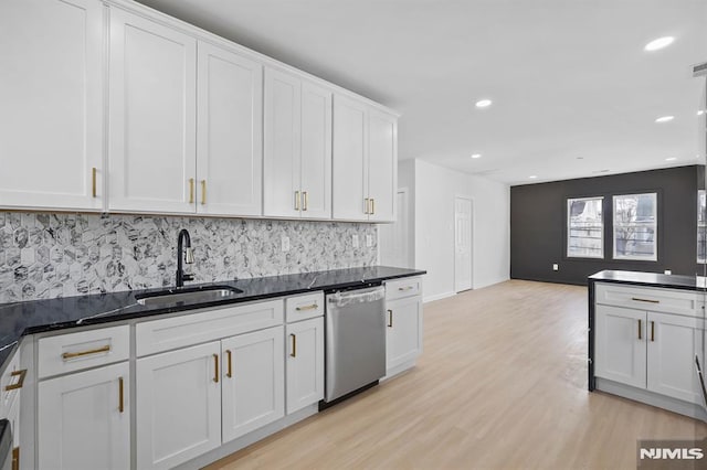 kitchen featuring a sink, white cabinetry, open floor plan, and dishwasher