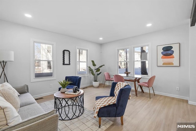 living area with light wood-style floors, baseboards, visible vents, and recessed lighting