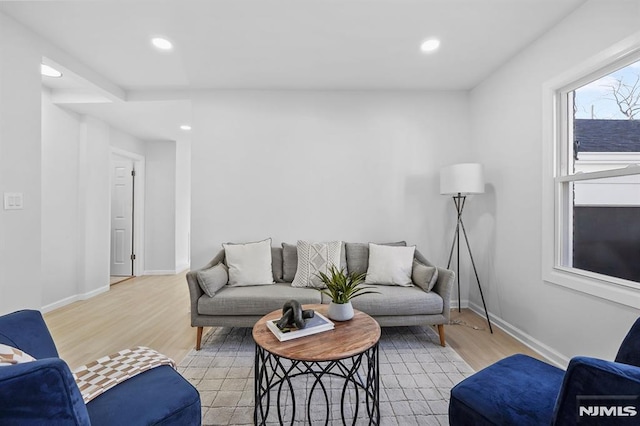 living area featuring light wood finished floors, baseboards, and recessed lighting