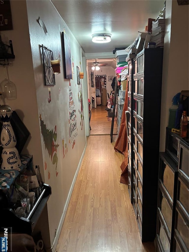 hall featuring light wood finished floors and baseboards