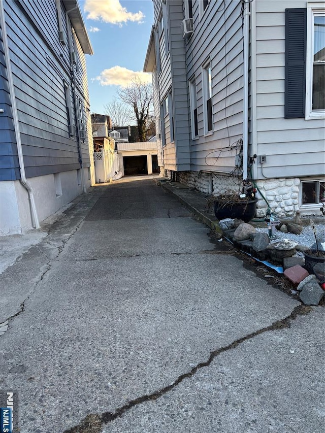 view of home's exterior with fence and driveway