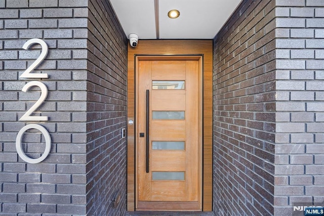 doorway to property featuring brick siding