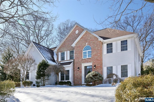 colonial inspired home featuring brick siding