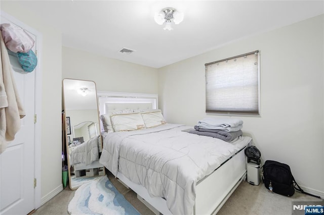 bedroom with light carpet, visible vents, and baseboards