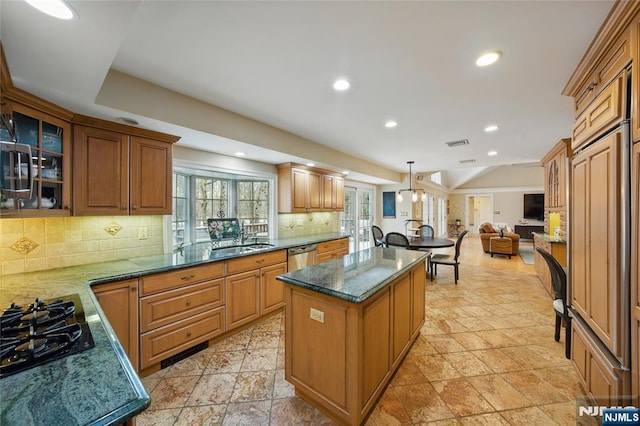 kitchen featuring a sink, a kitchen island, open floor plan, stainless steel dishwasher, and glass insert cabinets