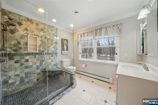 bathroom featuring a stall shower, toilet, crown molding, vanity, and a baseboard heating unit