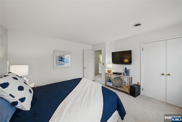 carpeted bedroom with a closet and visible vents