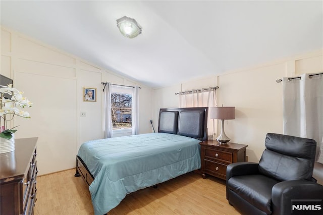 bedroom featuring light wood-type flooring and lofted ceiling