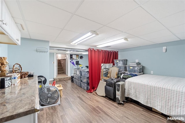 bedroom featuring light wood-type flooring and a paneled ceiling