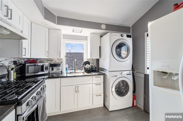 laundry area with laundry area, a sink, and stacked washing maching and dryer