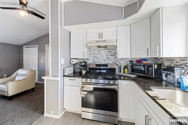 kitchen with appliances with stainless steel finishes, open floor plan, white cabinets, and under cabinet range hood