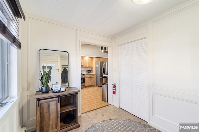 interior space featuring plenty of natural light, a decorative wall, and light tile patterned floors