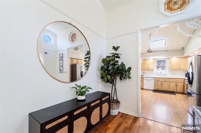 hall with dark wood-style floors, crown molding, and a sink