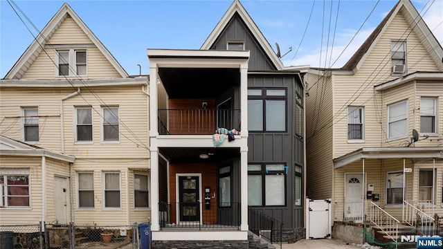 view of front of property featuring board and batten siding, a gate, and a fenced front yard