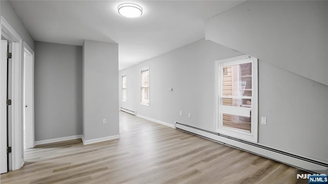 bonus room with a baseboard radiator, a baseboard heating unit, light wood-style flooring, and baseboards