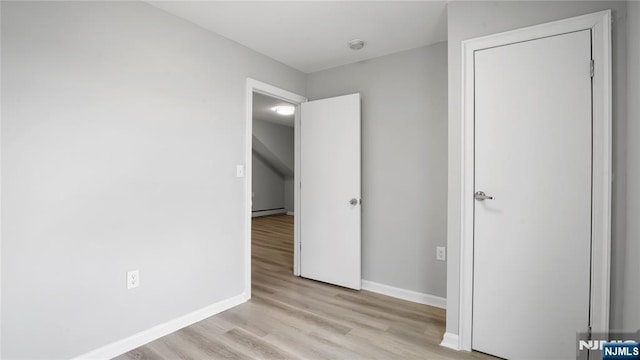 unfurnished bedroom with baseboards and light wood-style floors