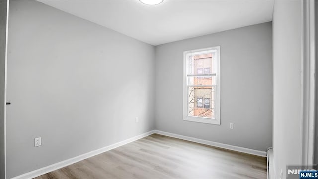 unfurnished room with light wood-style flooring and baseboards