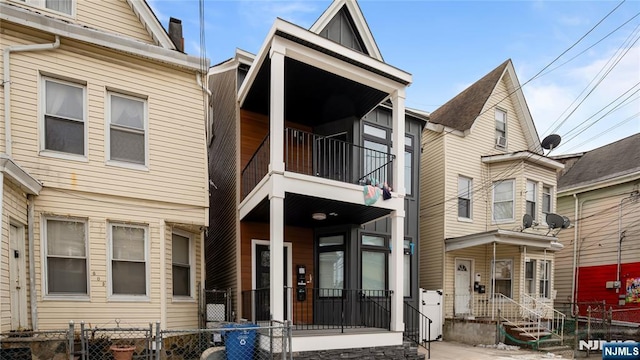 view of front facade with a fenced front yard and a balcony