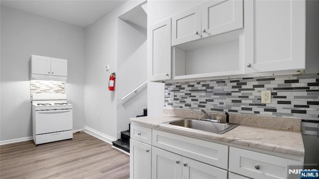 kitchen featuring white cabinetry, a sink, and gas range gas stove