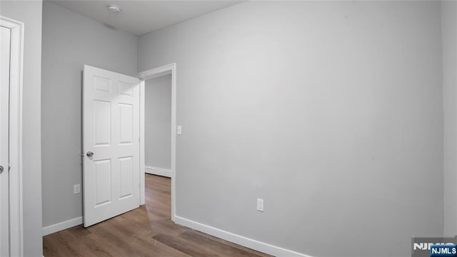 unfurnished bedroom featuring baseboards and wood finished floors