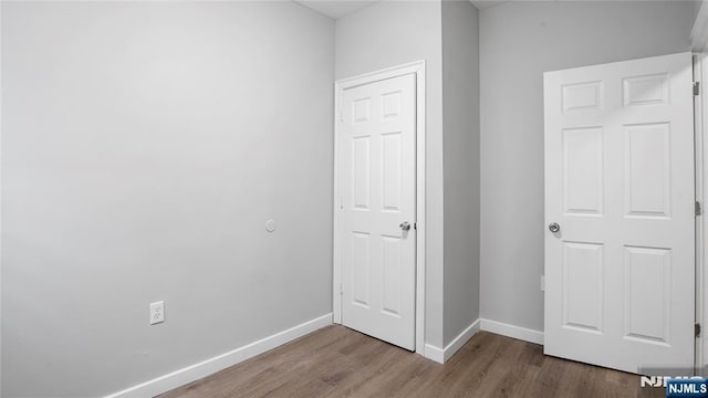 unfurnished bedroom featuring baseboards and wood finished floors