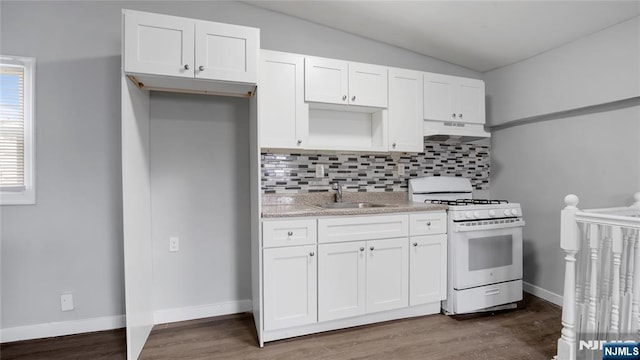 kitchen featuring under cabinet range hood, white gas range, white cabinets, and a sink