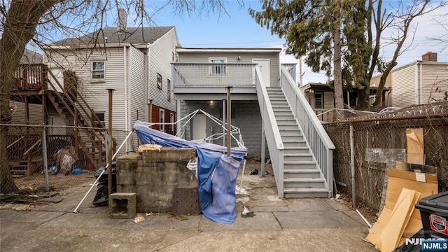 back of house featuring stairs and fence