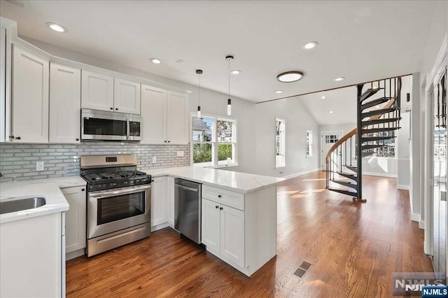 kitchen with stainless steel appliances, white cabinetry, and a peninsula