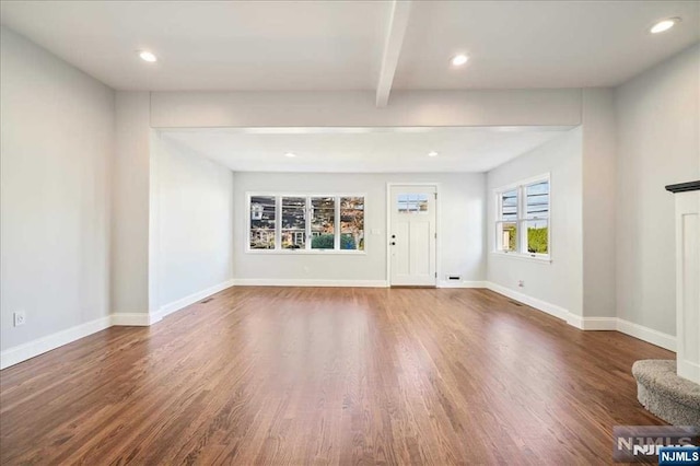 unfurnished living room featuring dark wood-style floors, beamed ceiling, recessed lighting, and baseboards