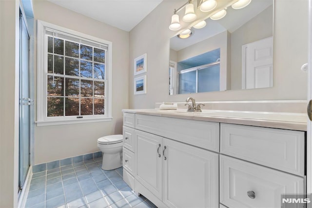 full bathroom featuring a stall shower, tile patterned flooring, vanity, and baseboards