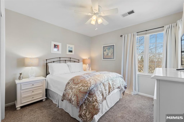 bedroom featuring light carpet, baseboards, visible vents, and a ceiling fan