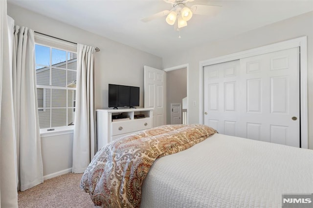 bedroom with ceiling fan, baseboards, a closet, and light colored carpet