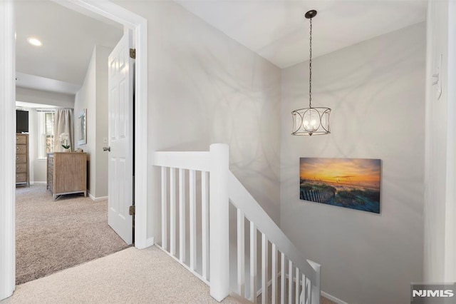 hall featuring recessed lighting, light colored carpet, an upstairs landing, a chandelier, and baseboards